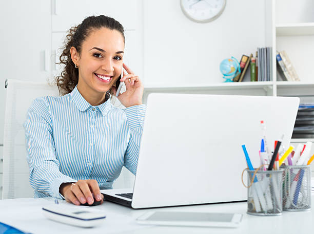 istock young woman talking by mobile in office 618063998