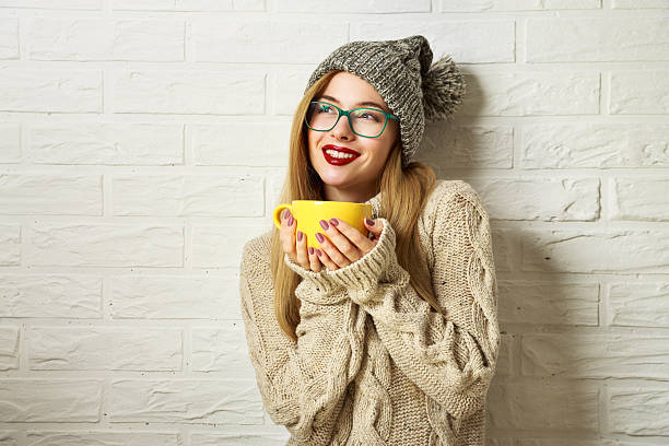 Smiling Hipster Girl in Winter Clothes with a Mug stock photo
