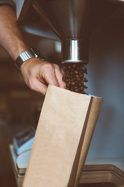 istock man filling paper bag with coffee beans 618071030
