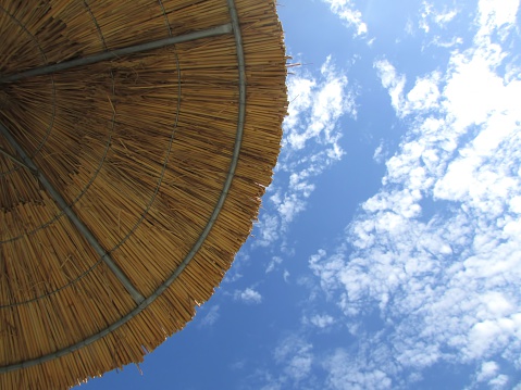 During a sunny afternoon, laying under a Straw parasol In Faliraki, Rhodes. 