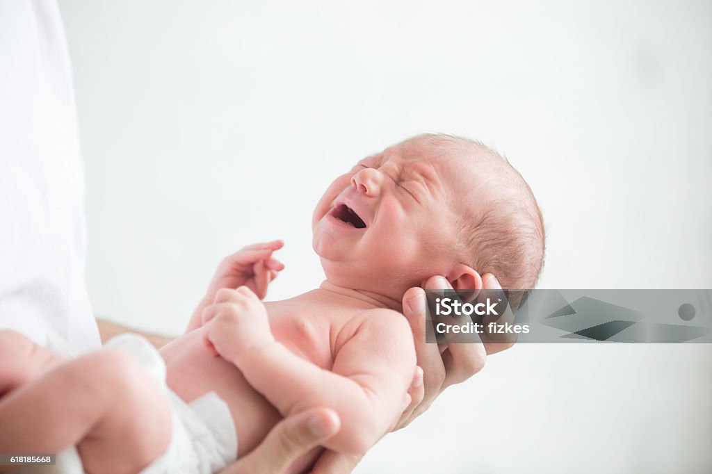 Portrait of a screaming newborn hold at hands Portrait of a screaming newborn hold at hands, family, healthy birth concept photo, close up Baby - Human Age Stock Photo