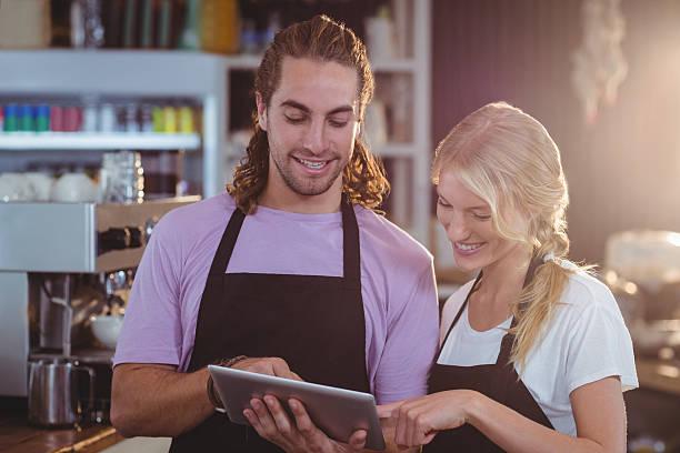 istock Smiling waiter and waitress using digital tablet at counter 618185962