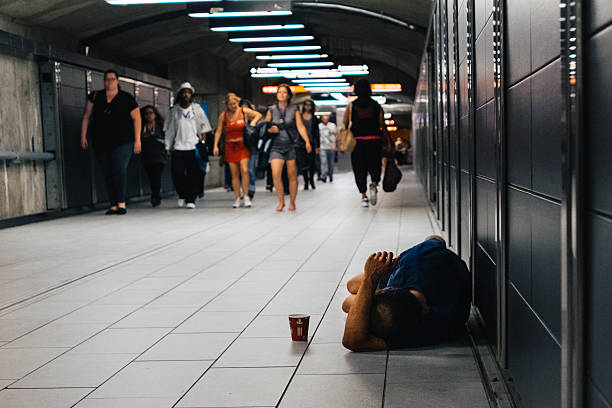 Homeless man sleeping on the floor Montreal metro Montreal, Canada - September 21, 2016: A homeless man is sleeping on the floor at Henri-Bourassa metro station, Montreal, Quebec. montreal underground city stock pictures, royalty-free photos & images