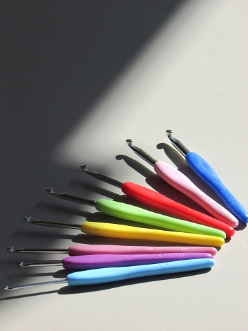 Colorful Knitting tools lying on neutral background.
