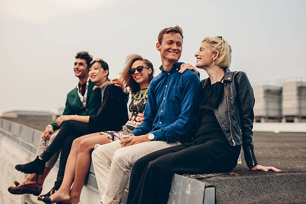 istock Men and women sitting together on rooftop 618187294