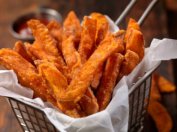 Basket of Sweet Potato French Fries Sweet Potato French Fries with Ketchup - Photographed on Hasselblad H3D2-39mb Camera sweet potato french fries stock pictures, royalty-free photos & images