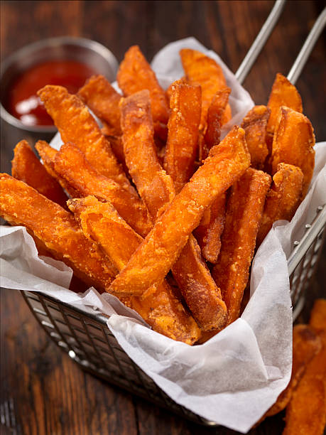 Basket of Sweet Potato French Fries Sweet Potato French Fries with Ketchup - Photographed on Hasselblad H3D2-39mb Camera sweet potato french fries stock pictures, royalty-free photos & images