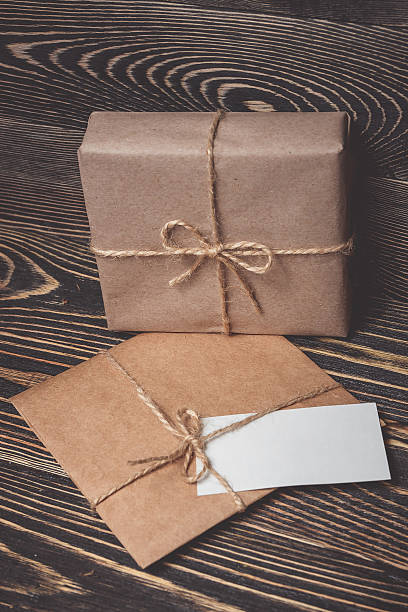 istock Vintage gift box with blank tag on old wooden background. 618189092