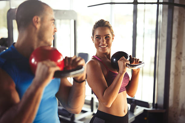 istock Two young athletic people doing kettlebell exercises at gym. 618193798