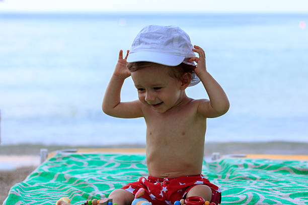istock Baby with cap on the beach 618194288