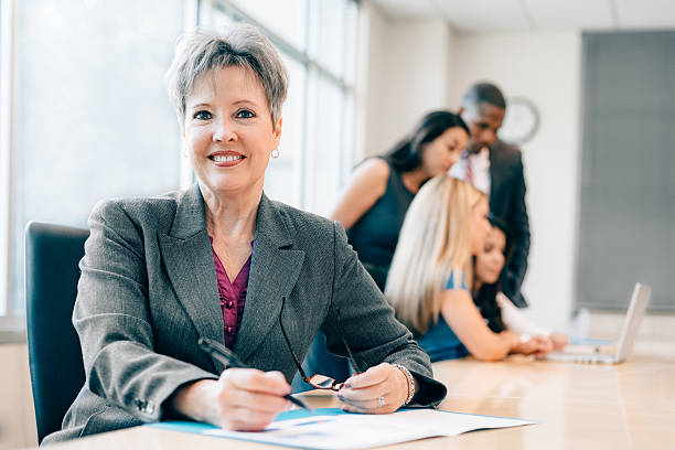Natural Team Leader Senior Business Woman Leading a team at work female role model stock pictures, royalty-free photos & images