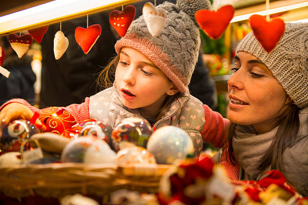 Christmas market mother and daughter selecting decoration on a Christmas market christmas market photos stock pictures, royalty-free photos & images