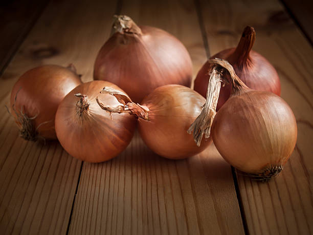 istock Brown onion on a wooden table 618198642