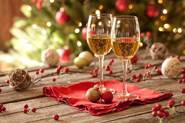 Christmas holiday white wine, old wood table, ornaments and tree