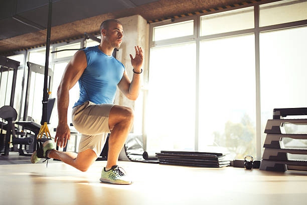 istock Man doing leg exercises with suspension straps at gym. 618200582