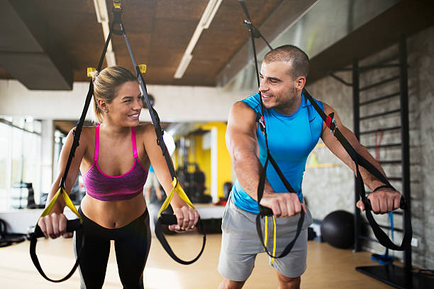 istock Couple doing arm exercises with suspension straps at gym. 618201092