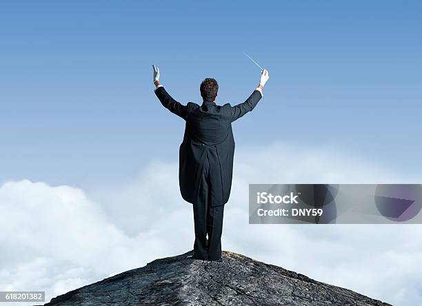 Musical Conductor On Top Of Mountain Top With Arms Raised Stock Photo - Download Image Now
