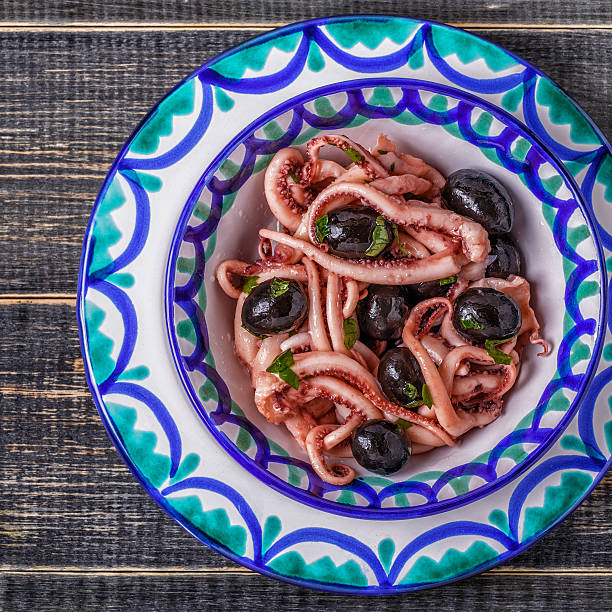 istock Grilled tentacle squids garnished with parsley and olives. 618201672