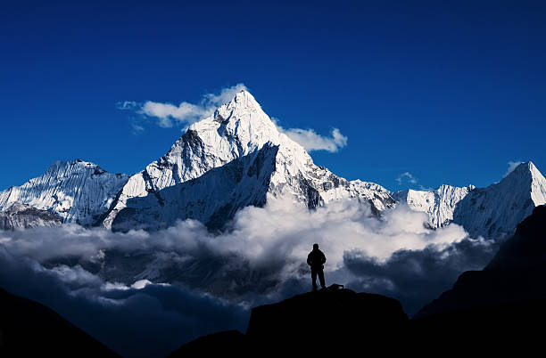 uomo che fa escursioni silhouette sull'everest, himalaya - himalayas mountain climbing nepal climbing foto e immagini stock