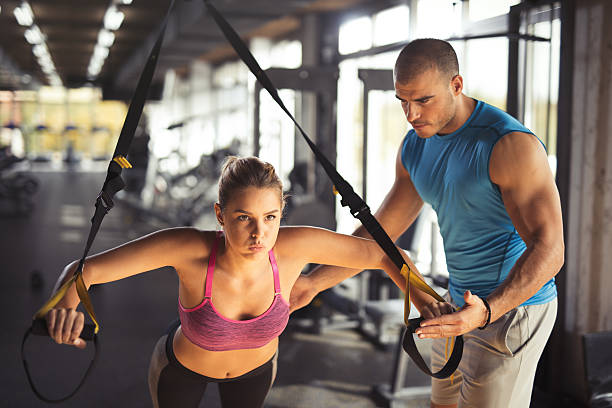istock Woman doing arm exercises with suspension straps at gym. 618202552