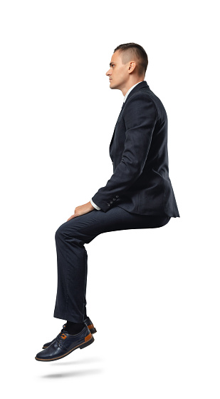 Hombre de negocios de perfil en posición sentada aislado sobre el blanco photo