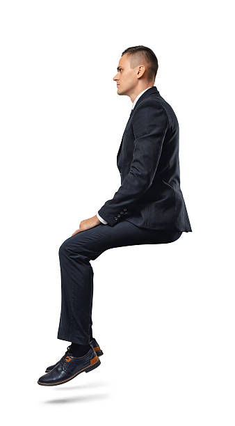 Businessman in profile in sitting position isolated on the white A businessman in profile in sitting position isolated on the white background. Business and management. Poses and gestures. sitting stock pictures, royalty-free photos & images