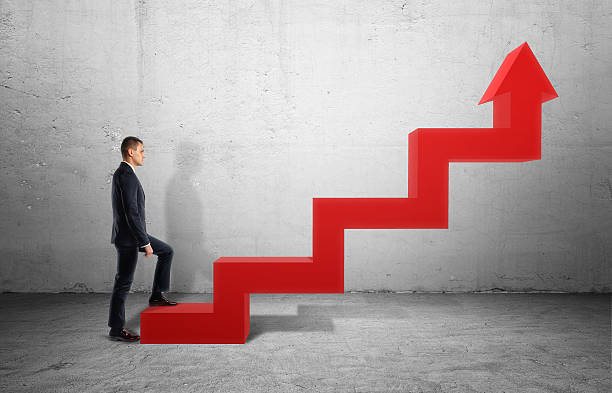 istock Businessman in profile walking up big red arrow in form 618203142