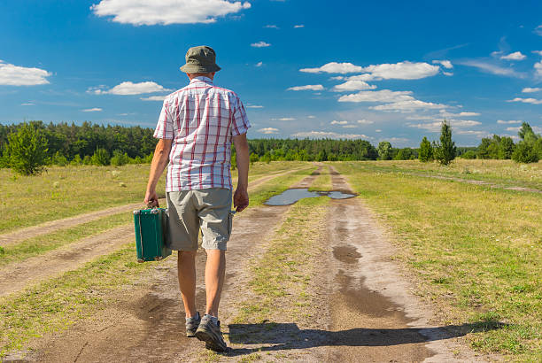 istock Man  walking on a summer country road 618203270