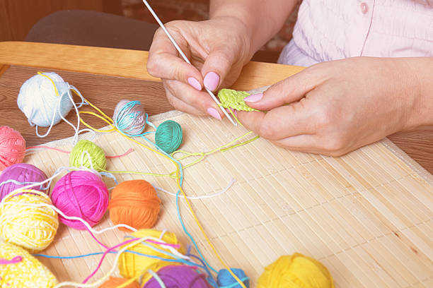 istock Colorful clews yarn and female hand crocheting 618204136