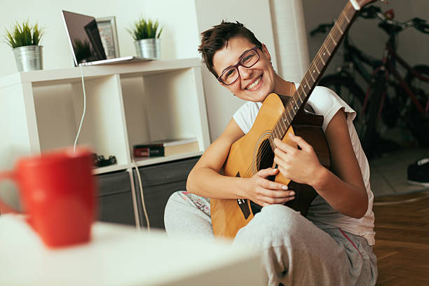 Jovem mulher tocando guitarra - foto de acervo