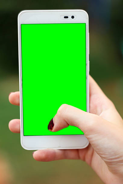 Woman hand holding mobile phone with chroma green stock photo