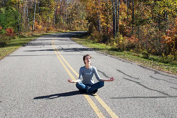 Pretty girl meditates on a forest road, Marinette county; Wisconsin;