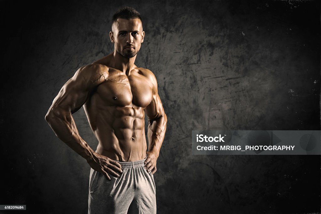 Strong Muscular Men Portrait of a physically fit, muscular young man without a shirt.  Muscular Build Stock Photo