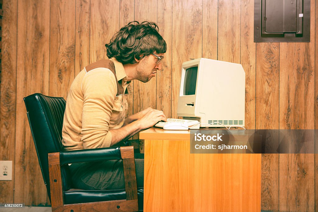 Funny Nerdy Man mirando intensamente a vintage computer - Foto de stock de Retro libre de derechos