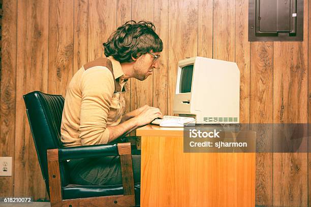 Funny Nerdy Man Mirando Intensamente A Vintage Computer Foto de stock y más banco de imágenes de Retro