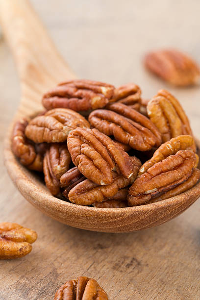 istock pecan nuts in a wooden spoon 618210404