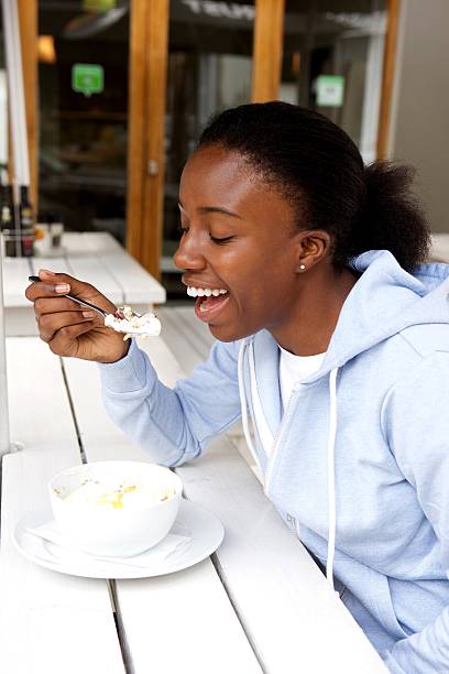 istock Happy african woman eating breakfast 618210642