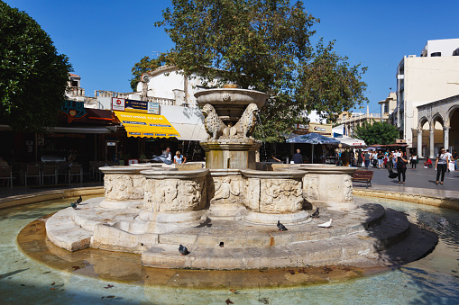 Heraklion, Greece - October 12, 2016: People are walking near Morosini fountain on a pedestrian shopping street of the city