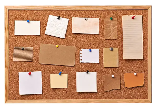 close up of note papers on a corkboard