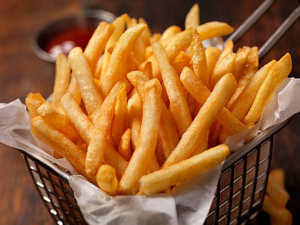 basket of famous fast food french fries - focus on foreground selective focus focus household equipment imagens e fotografias de stock