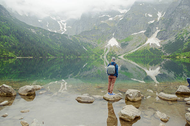 istock man relaxing on the lake and mountains sunny landscape 618217058