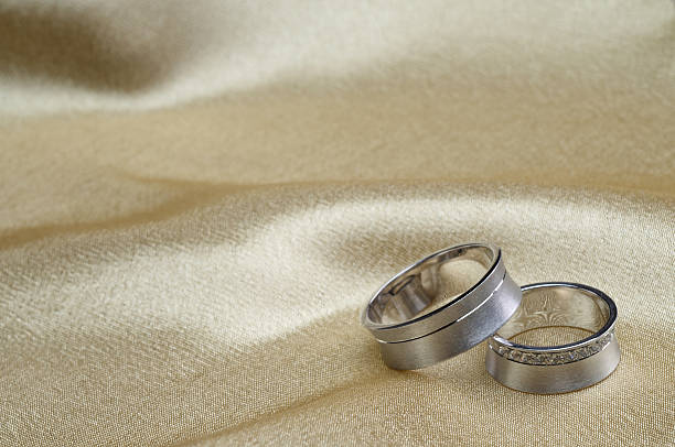 istock Wedding rings on satin with copy space 618217594