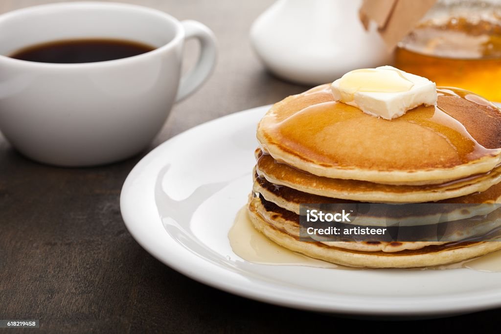 Brunch Panckes with butter and syrup with coffee in the background Pancake Stock Photo