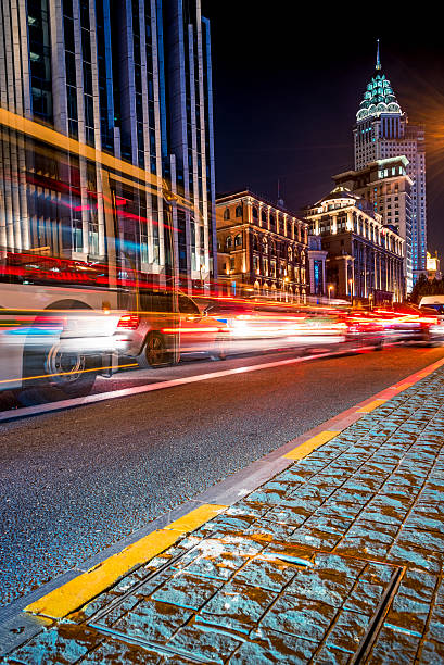istock blurred traffic light trails on road with cityscape 618221186