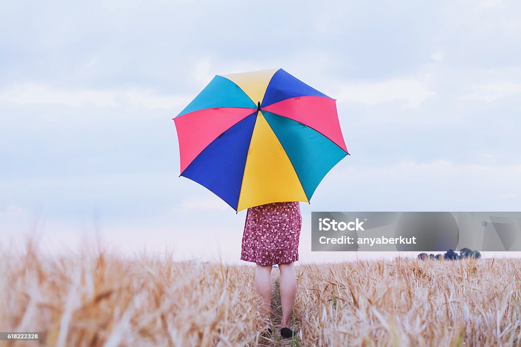 woman with colorful umbrella woman with colorful umbrella in the field, optimistic positive multicolored background with copyspace Umbrella Stock Photo