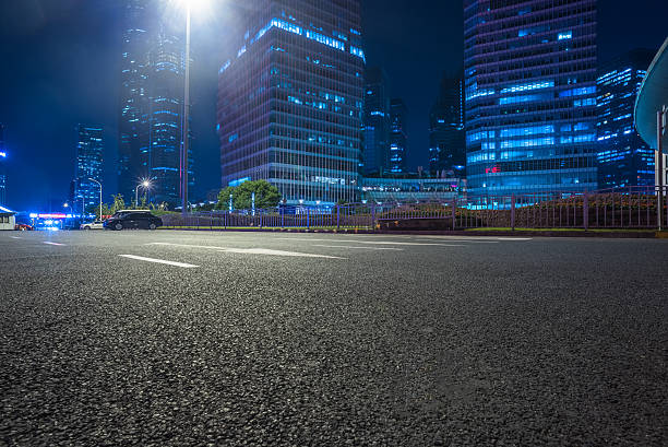 strada asfaltata vuota attraverso la città moderna. - downtown district skyline skyscraper asphalt foto e immagini stock