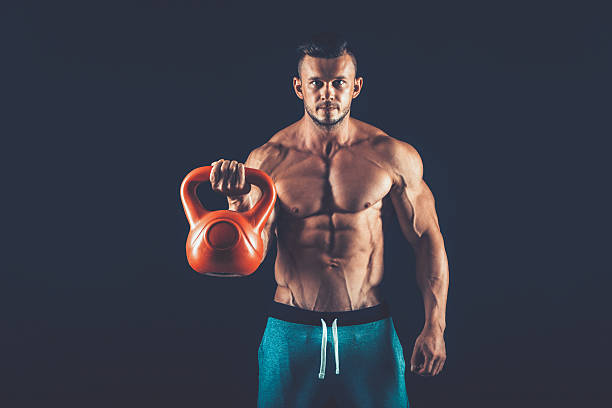 istock Fitness man doing a weight training by lifting  heavy kettlebell 618315316