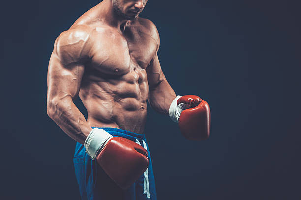 istock Muscular boxer in studio shooting, on black background. 618316368