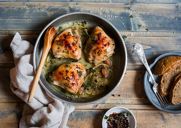 запеченная курица в белом вине на сковороде. - roast garlic стоковые фото и изображения