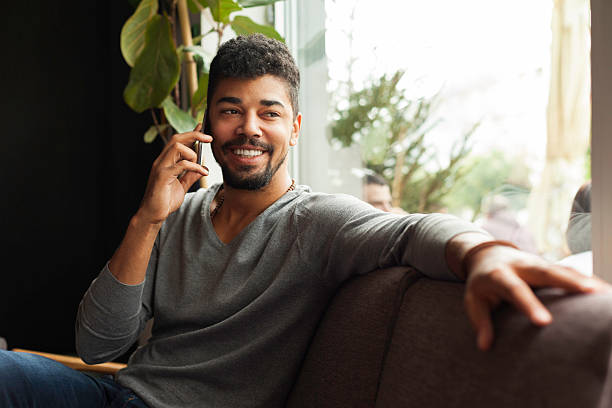 istock Young happy man talking on the phone in a cafe 618318788